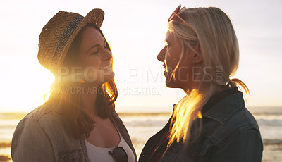 Buy stock photo Shot of an affectionate and happy young couple bonding and spending the day together outdoors near the beach
