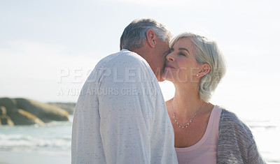 Buy stock photo Cropped shot of an affectionate senior couple having an intimate moment at the beach on a summer's day