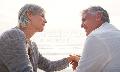 Buy stock photo Cropped shot of an affectionate senior couple having an intimate chat while sitting on loungers at the beach