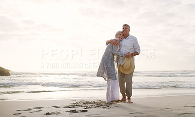 Buy stock photo Full length shot of an affectionate senior couple embracing each other at the beach during the day