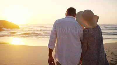 Buy stock photo Rearview shot of an unrecognizable senior couple walking towards the beach at sunset