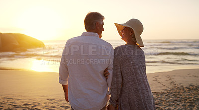 Buy stock photo Rearview shot of an affectionate senior couple walking towards the beach at sunset