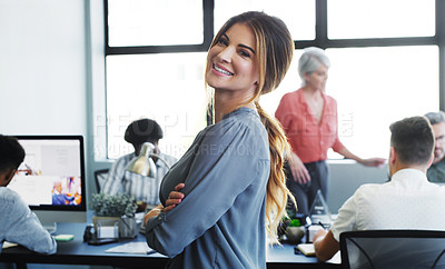 Buy stock photo Portrait of a confident young businesswoman working in a modern office with her colleagues in the background
