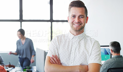 Buy stock photo Portrait of a confident young businessman working in a modern office with his colleagues in the background
