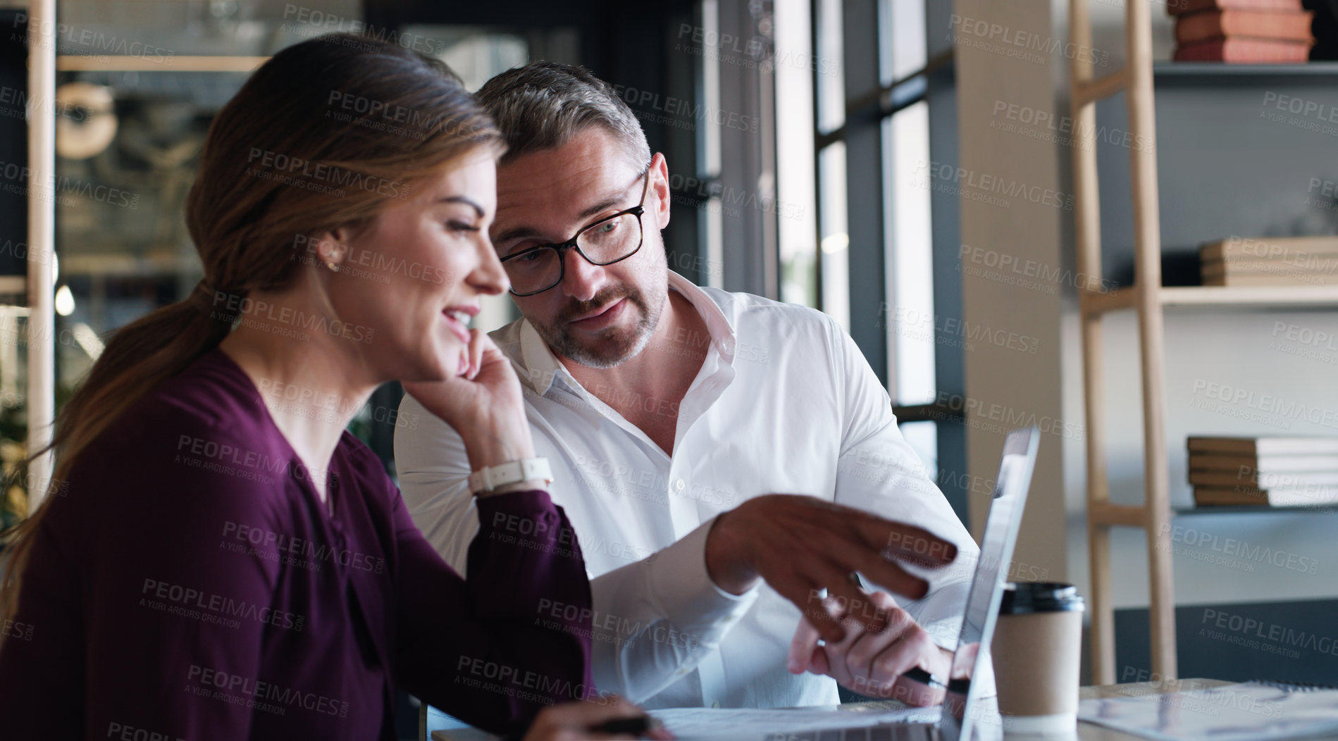 Buy stock photo Shot of a businessman and businesswoman using a laptop and having a discussion in a modern office