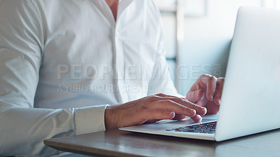 Buy stock photo Cropped shot of a businessman using a laptop in a modern office