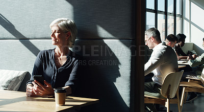 Buy stock photo Shot of a mature businesswoman using a smartphone in a modern office
