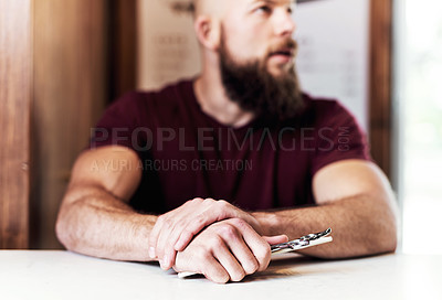 Buy stock photo Cropped shot of a barber holding a pair of scissors inside his barbershop