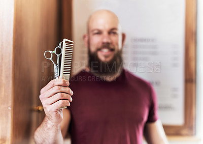 Buy stock photo Cropped shot of a barber holding a hair comb and a pair of scissors inside his barbershop