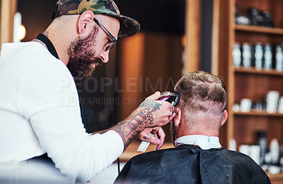 Buy stock photo Cropped shot of a handsome young barber giving a client a haircut inside his barbershop