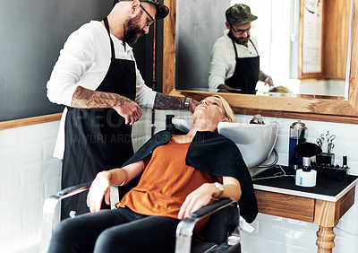 Buy stock photo Cropped shot of an attractive young woman getting her hair washed and styled by a hairdresser inside a salon