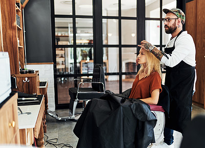 Buy stock photo Full length shot of an attractive young woman getting her hair styled and treated by a hairdresser at a salon