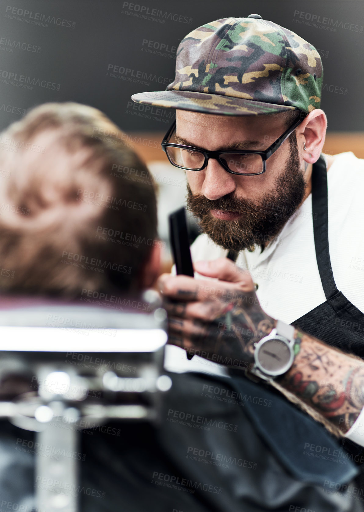 Buy stock photo Cropped shot of a handsome young barber trimming and lining up a clients beard inside a barbershop