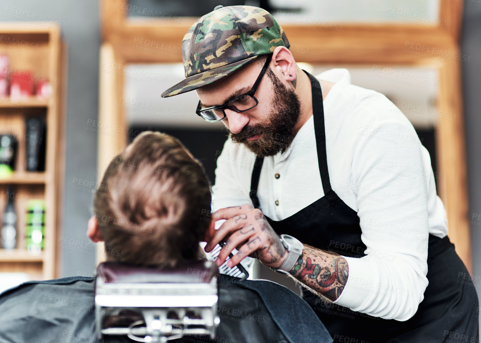 Buy stock photo Cropped shot of a handsome young barber trimming and lining up a clients beard inside a barbershop
