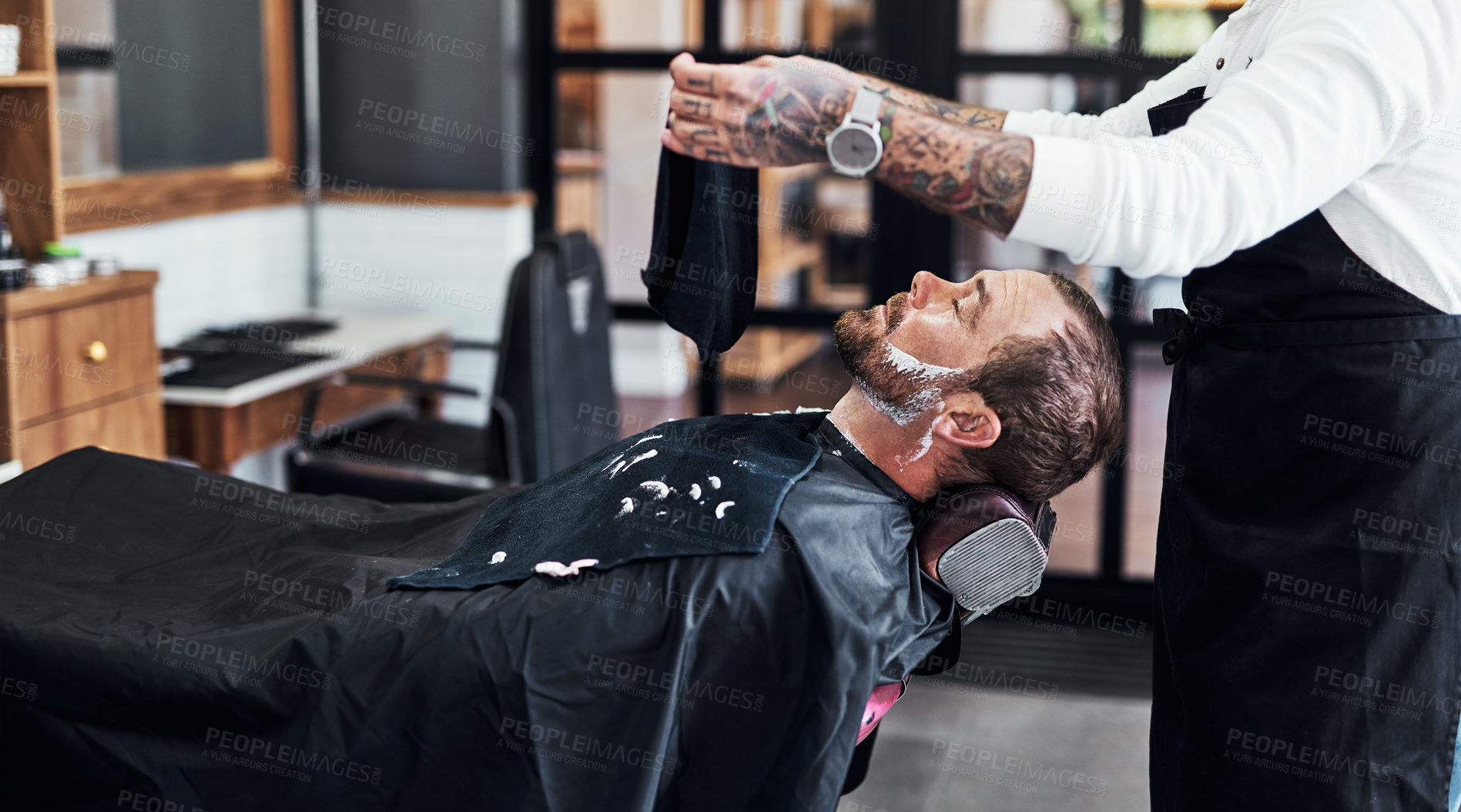 Buy stock photo Beard, client and man in barbershop with hair care, shave and tools for trendy hairstyle at small business. Style, barber and customer in chair for grooming service, creative haircut and facial trim.