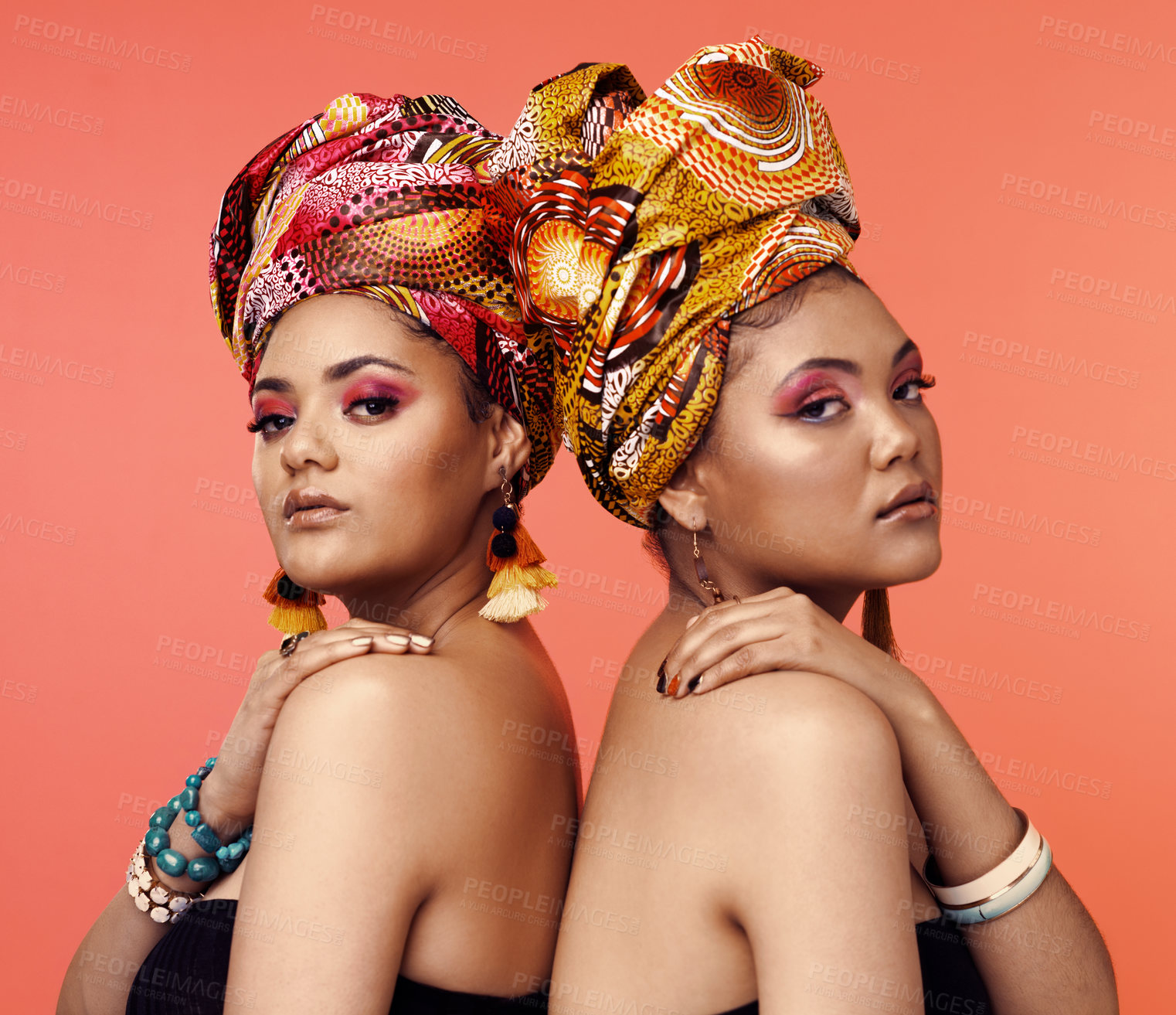 Buy stock photo African fashion, cosmetics and portrait of women on orange background with accessory, makeup and beauty. Glamour, luxury and female people in exotic jewelry, traditional style and scarf in studio