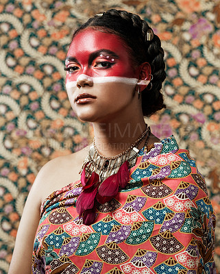 Buy stock photo Portrait of an attractive young woman dressed in traditional attire and makeup posing against a patterned background