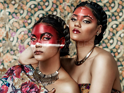 Buy stock photo Culture, paint and portrait of girls, traditional and art on face, color and respect for tribe. Pattern, background and twins of women, proud and confident with makeup, red and together or beauty