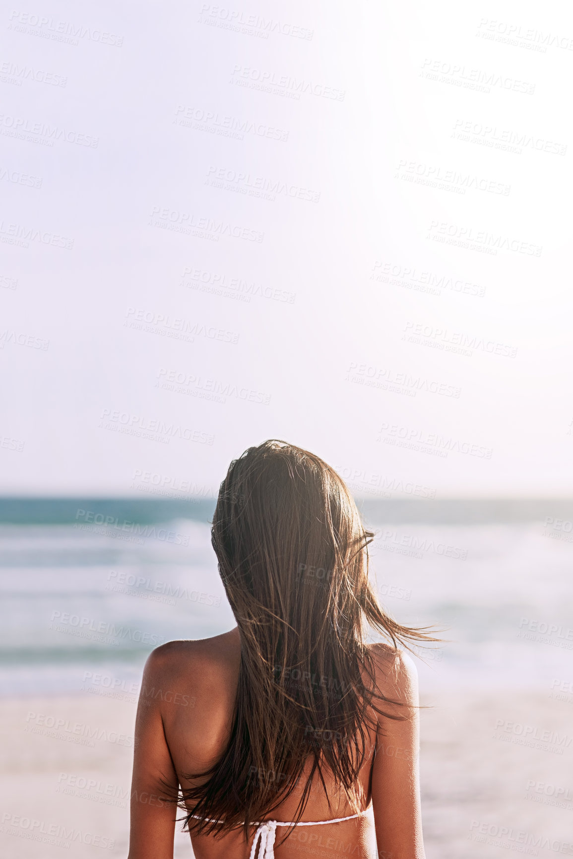 Buy stock photo Rearview shot of an unrecognizable young woman at the beach