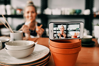 Buy stock photo Cropped shot of an attractive mature woman using her cellphone to record her pottery process for her blog