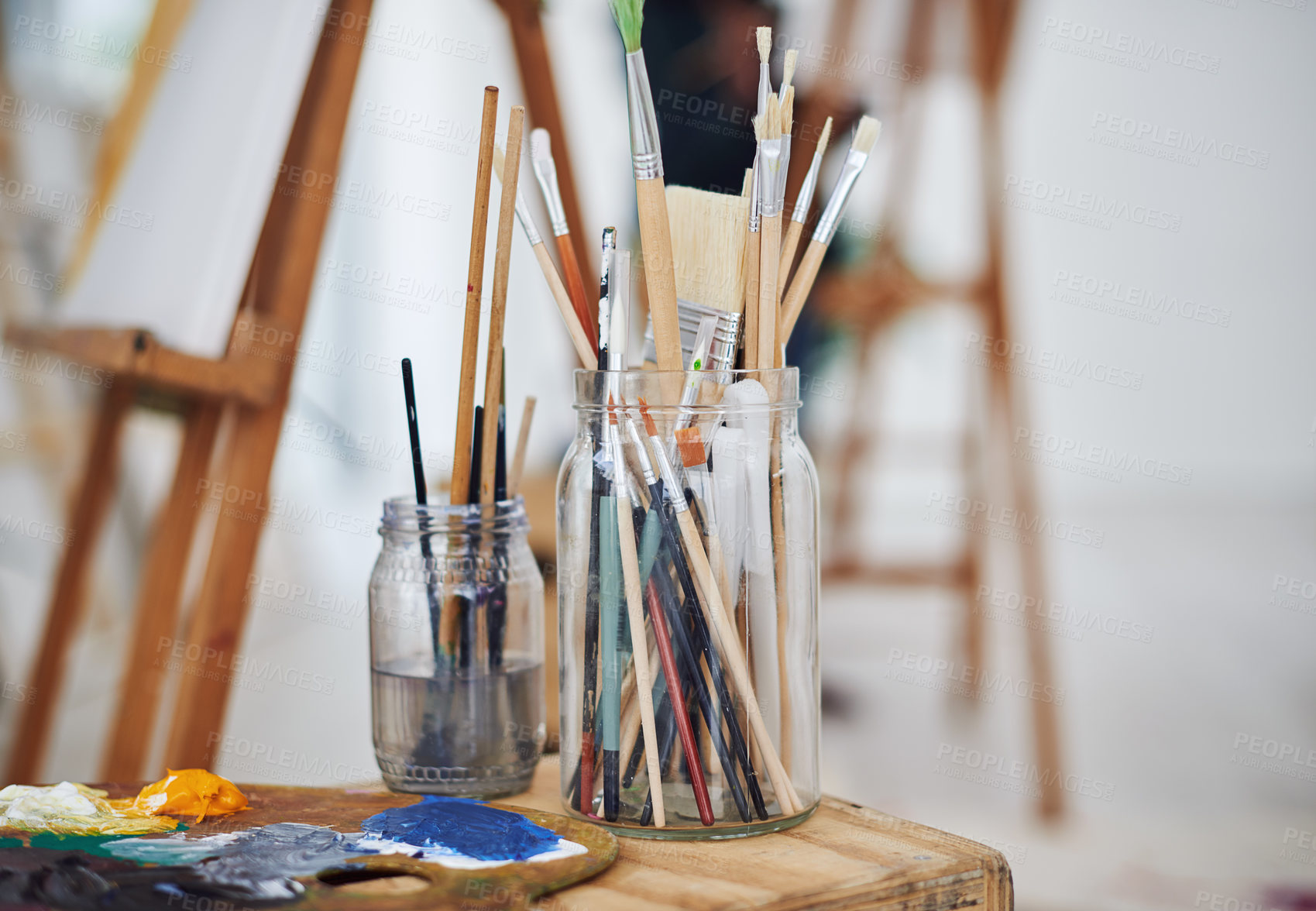Buy stock photo Still life shot of paintbrushes in jars in a art studio