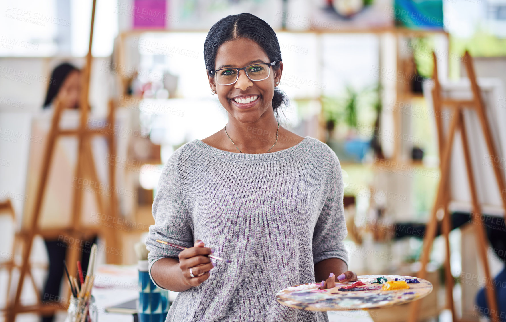 Buy stock photo Cropped shot of a beautiful young woman smiling at the camera in a art studio