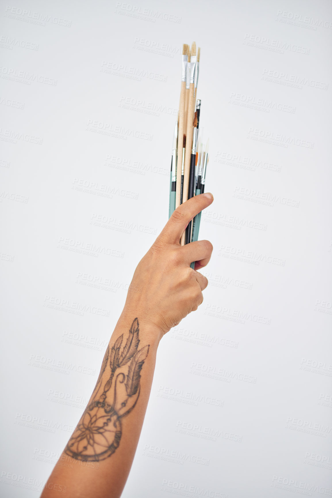 Buy stock photo Cropped shot of an unrecognizable woman holding paintbrushes against a white background
