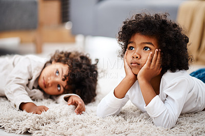 Buy stock photo Cropped shot of two adorable little boys lying down on a carpet and watching tv together at home