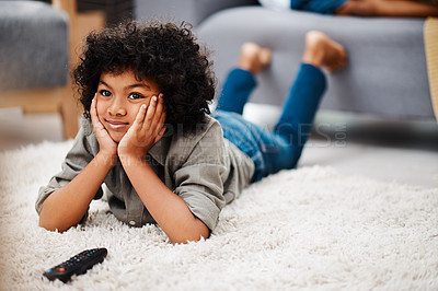Buy stock photo Full length shot of an adorable little boy lying down on a carpet and watching tv at home