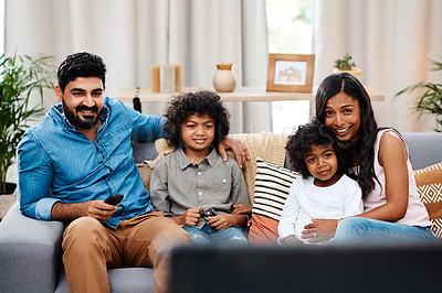 Buy stock photo Cropped shot of a beautiful young family sitting on sofa and watching tv together at home