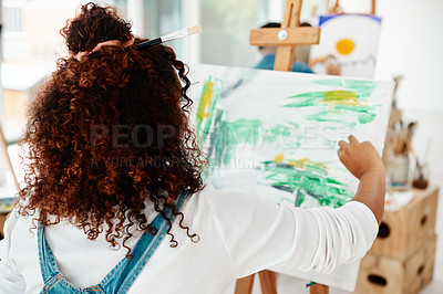 Buy stock photo Cropped shot of an unrecognizable artist sitting and painting on a canvas during a painting session in an art studio