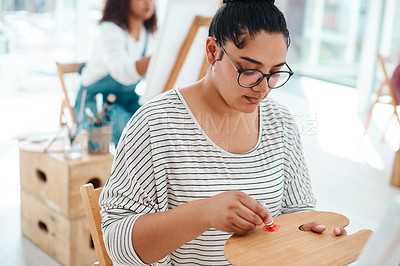 Buy stock photo Cropped shot of an attractive young artist squeezing paint onto a palette during an art class in the studio