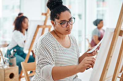 Buy stock photo Cropped shot of an attractive young woman sitting with her friends and painting during an art class in the studio