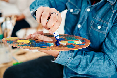 Buy stock photo Cropped shot of an unrecognizable artist squeezing paint onto a palette during an art class in the studio