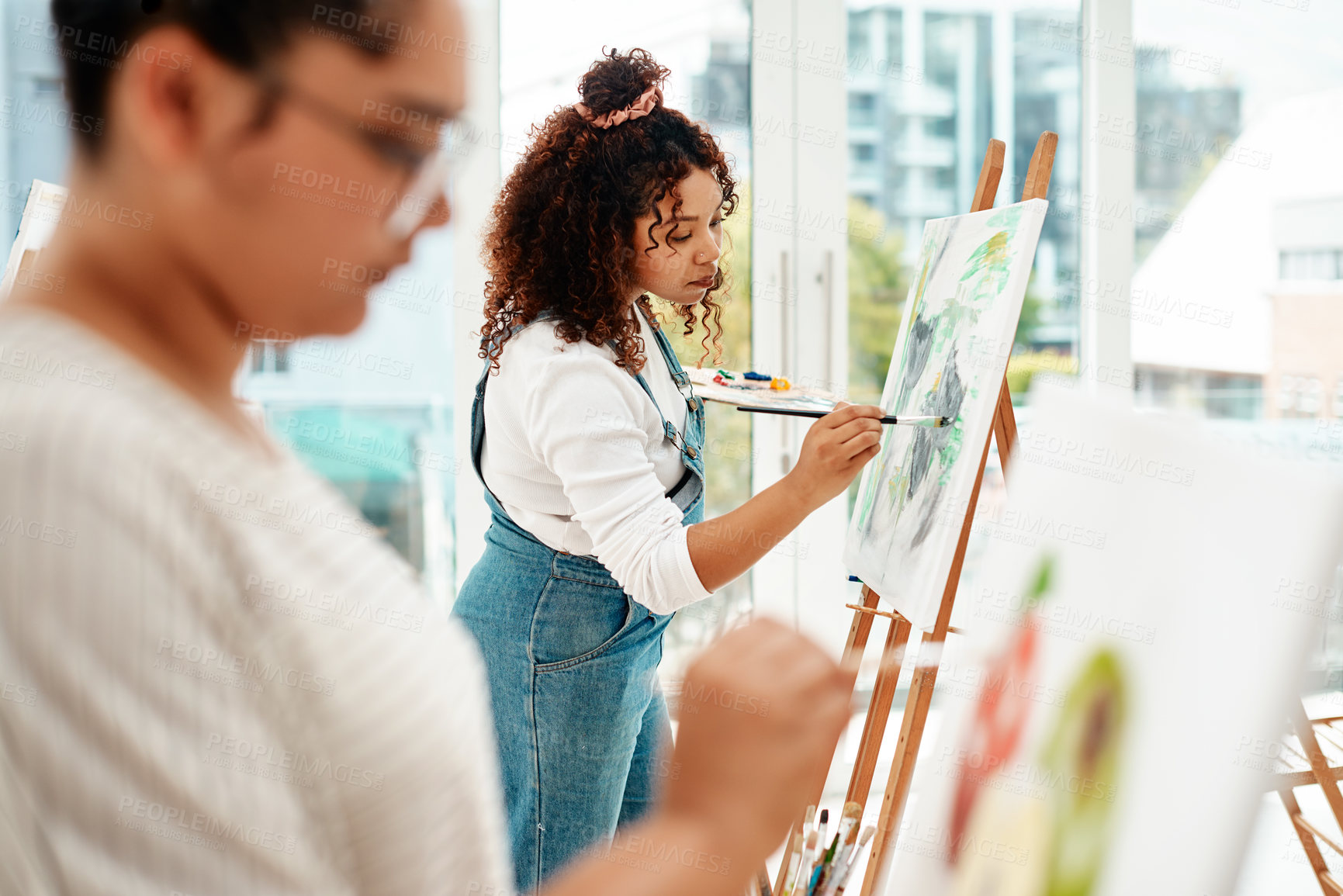 Buy stock photo Cropped shot of an attractive young woman standing with her friend and painting during an art class in the studio