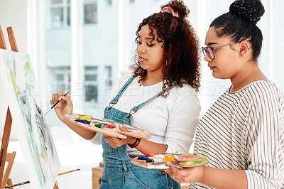 Buy stock photo Cropped shot of an attractive young woman standing with her friend and painting during an art class in the studio