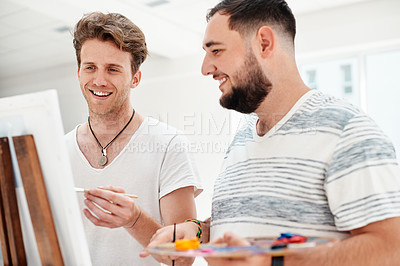 Buy stock photo Cropped shot of a handsome young man standing with his friend and painting during an art class in the studio