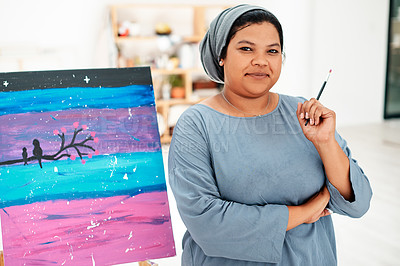 Buy stock photo Cropped portrait of an attractive young artist standing next to her painting during an art class in the studio