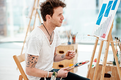 Buy stock photo Cropped shot of a handsome young artist sitting alone and painting during an art class in the studio