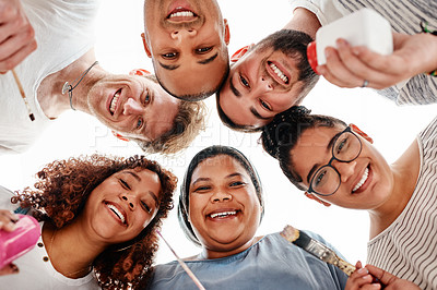 Buy stock photo Low angle portrait of a diverse group of friends huddled together during an art class in the studio