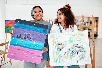 Buy stock photo Cropped portrait of two attractive young women standing together and holding their artwork after an art class in the studio