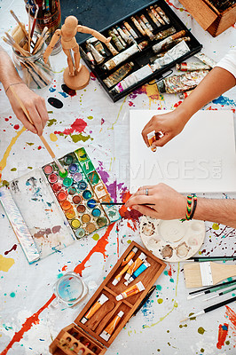 Buy stock photo High angle shot of an unrecognizable group of artists sitting together and painting during an art class in the studio