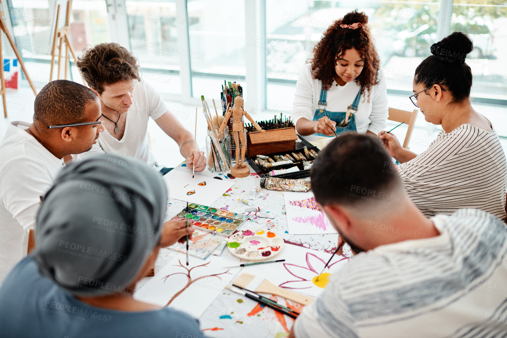 Buy stock photo Cropped shot of a diverse group of artists sitting together and painting during an art class in a studio
