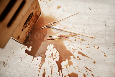 Buy stock photo High angle shot of spilled coffee and paintbrushes on the floor after an art class in an empty studio