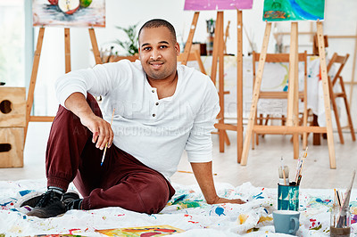 Buy stock photo Full length portrait of a handsome young artist sitting alone and painting during an art class in the studio