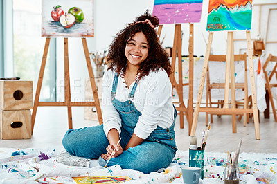 Buy stock photo Full length portrait of an attractive young artist sitting alone and painting during an art class in the studio
