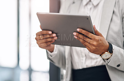 Buy stock photo Cropped shot of an unrecognizable businesswoman using a digital tablet inside her office