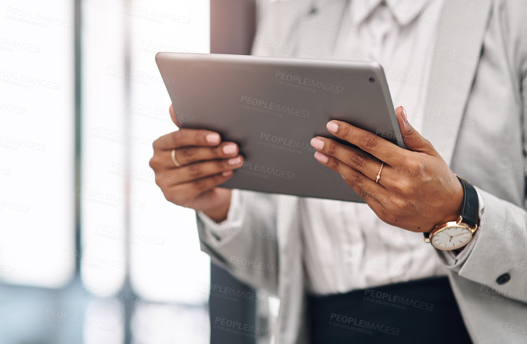 Buy stock photo Cropped shot of an unrecognizable businesswoman using a digital tablet inside her office