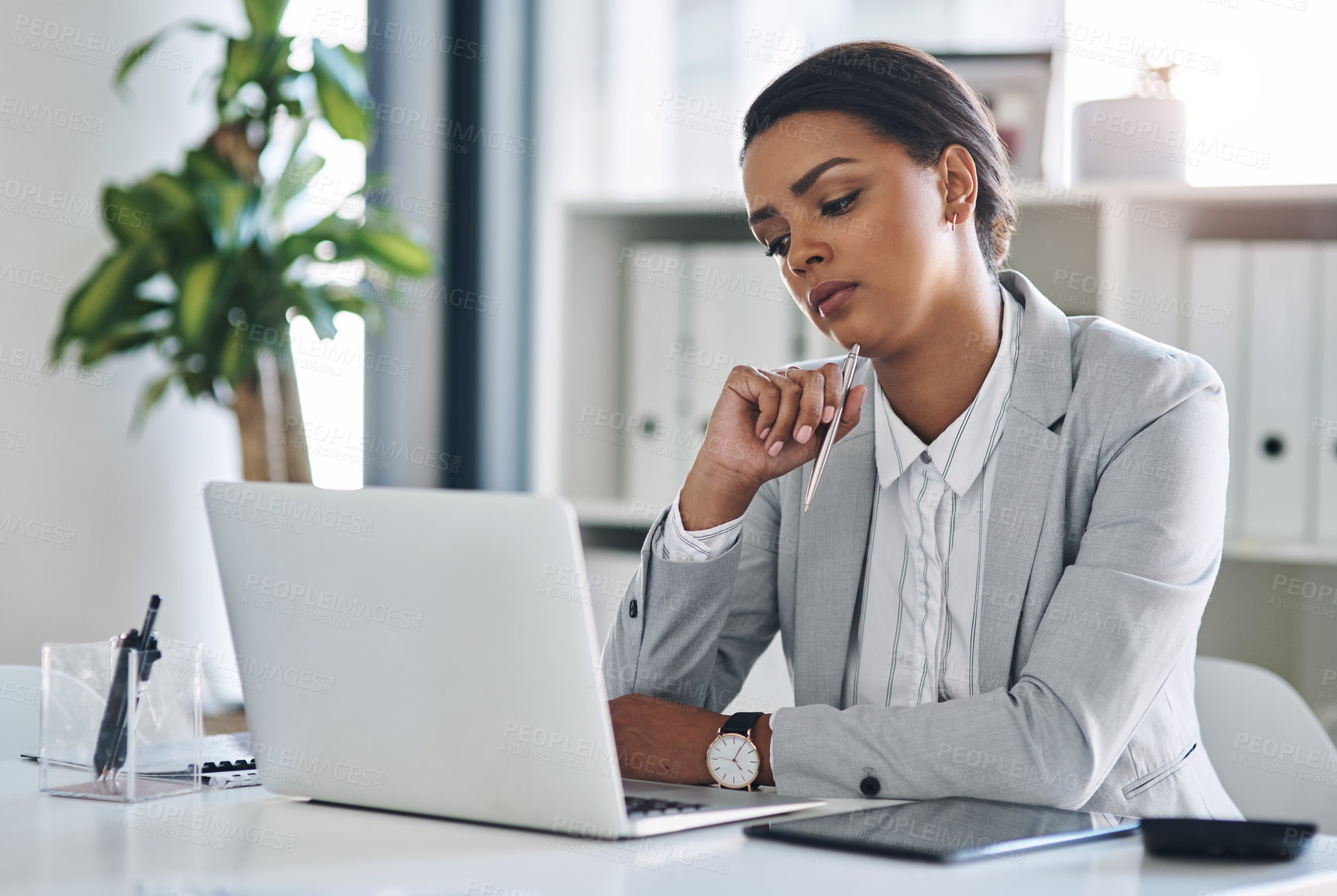 Buy stock photo Cropped shot of an attractive young businesswoman working on a laptop inside her office