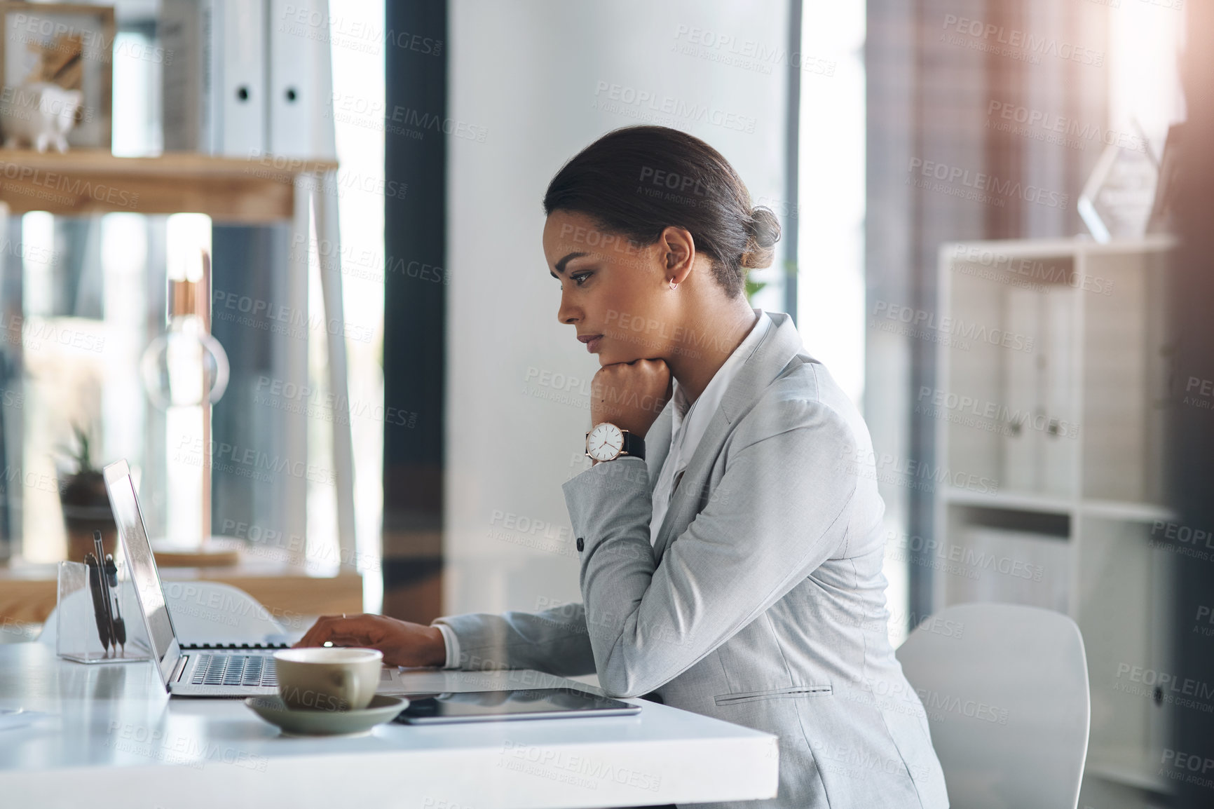 Buy stock photo Cropped shot of an attractive young businesswoman working on a laptop inside her office